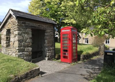 Red phone box and bus stop in Bridestowe