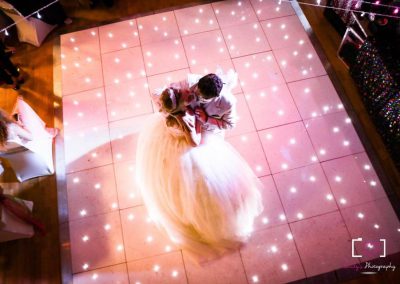 Wedding couple dancing on a lit dancefloor