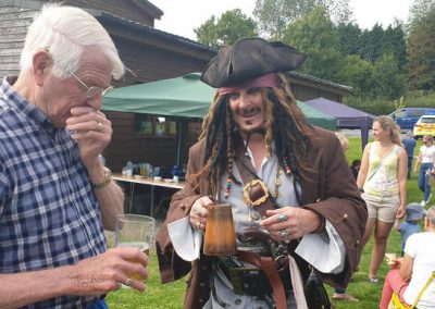 Two men chatting at Village Hall fun day one is dressed as a pirate